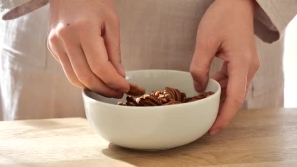 Pecan nuts. woman pours nuts into cup . Shelled fresh organic nuts.slow motion.shelled pecans. Healthy fats. Keto diet ingredient. - Footage, Video