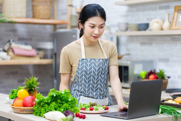 image of asian woman preparing salad in the kitchen - Photo, Image