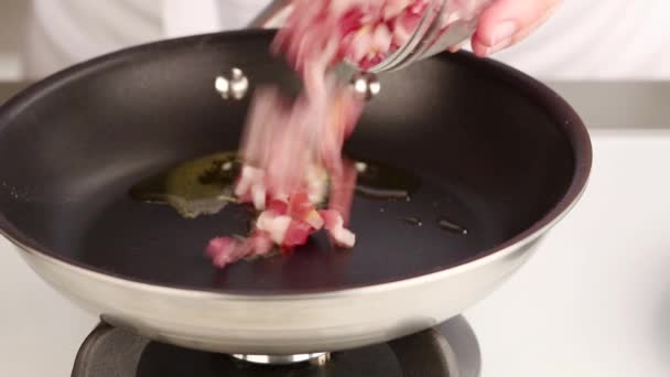 Bacon tagliato a dadini che viene aggiunto a una padella
 - Filmati, video