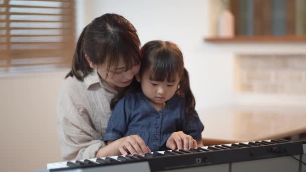 Eltern und Kind üben Klavierspielen - Filmmaterial, Video