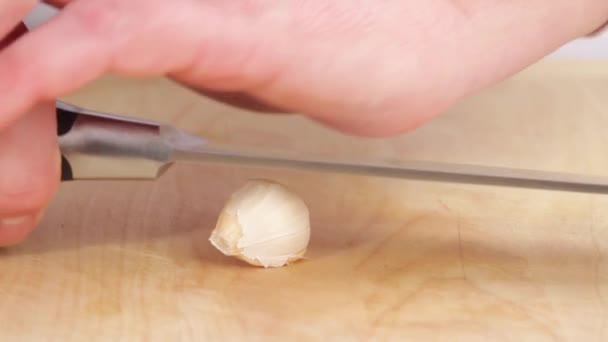 Knoblauchzehe mit einer Messerklinge zerquetscht - Filmmaterial, Video