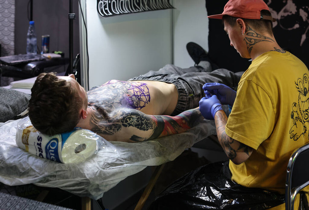 Krakow, Poland -  June 12, 2022: Unidentified  participant at 15th Tattoofest Convention in Cracow. One of the most prestigious tattoo festivals. Tattoo artist at work.  - Foto, immagini