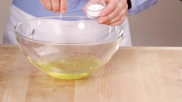 Ασπράδια αυγού είναι χτυπημένο με μια πρέζα αλάτι - Πλάνα, βίντεο