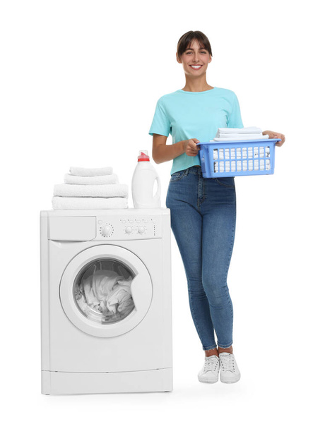 Beautiful woman with laundry basket near washing machine on white background - Foto, afbeelding