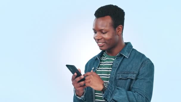 Teléfono, búsqueda y hombre negro en el estudio con las redes sociales, texto o riéndose de meme sobre fondo azul. Smartphone, aplicación y persona africana con cómic en línea, mensaje o divertido, móvil o comunicación. - Imágenes, Vídeo