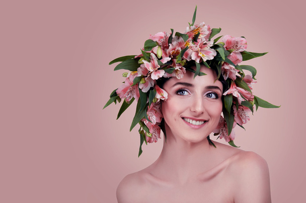 Nuori nainen yllään vaaleanpunaisia kukkia hänen päänsä
 - Valokuva, kuva