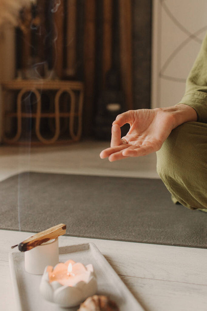 Žena cvičící jógu a meditaci doma sedící v lotosu pózuje na podložce jógy, uvolněná se zavřenýma očima. Vědomý koncept meditace. Blahobyt. Bez zaostření a efektu šumu. - Fotografie, Obrázek