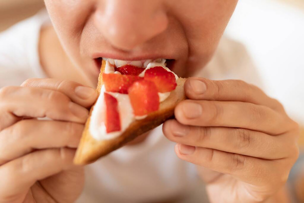 woman enjoying a snack of toast with strawberries and yogurt. - Photo, Image