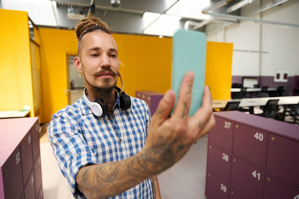 Freelancer vezme selfie v kancelářských prostorách, stylový interiér v kooperačním prostoru - Fotografie, Obrázek