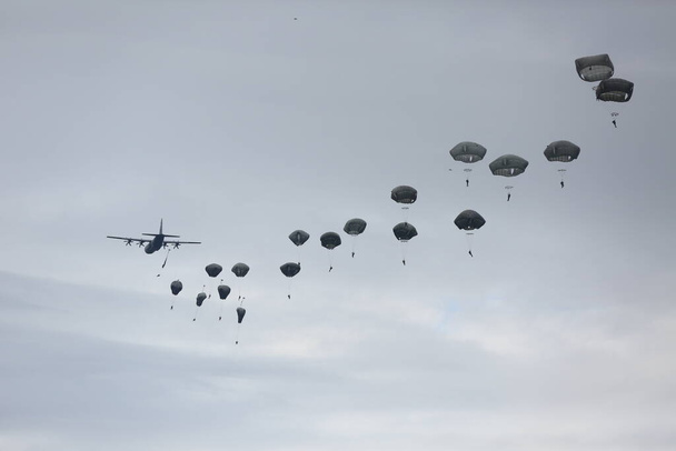 viele Fallschirmspringer am bewölkten Himmel  - Foto, Bild