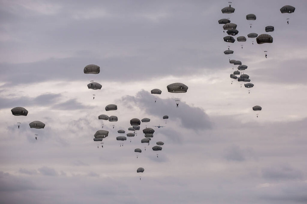 viele Fallschirmspringer am bewölkten Himmel   - Foto, Bild