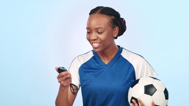 Football, sports coach and black woman with stopwatch in studio isolated on blue background mockup. Soccer, watch and happy personal trainer check clock time, monitor workout progress or performance. - Footage, Video