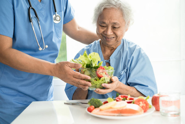 Asiatico anziana donna paziente mangiare salmone bistecca colazione con verdura sano cibo in ospedale. - Foto, immagini