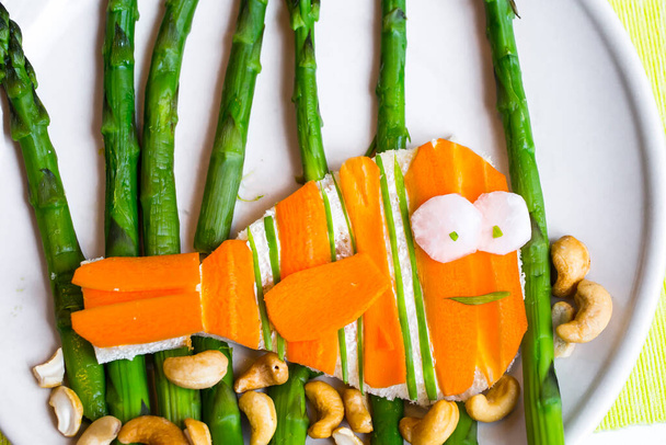 espárragos, zanahorias, queso y anacardos en forma de sándwich de pescado para niños - Foto, Imagen