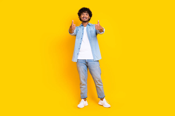 Full length photo of satisfied man with wavy hairstyle wear jeans shirt showing thumbs up good job isolated on yellow color background. - Zdjęcie, obraz