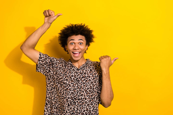 Portrait of funky person with chevelure wear leopard shirt indicating at unbelievable sale empty space isolated on yellow color background. - Foto, Imagem