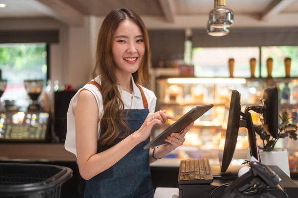 An Asian young Cashier woman working in supermarket - Foto, Imagem