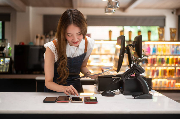 An Asian young Cashier woman working in supermarket - Foto, Imagen