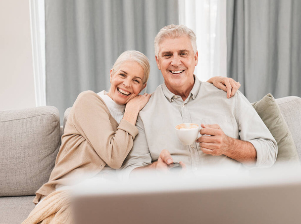 Old people, home and watching tv with coffee and happiness together in retirement with comedy and partner. Love, care and online streaming, funny tv show with tea and couple relax on couch for movie. - Photo, Image