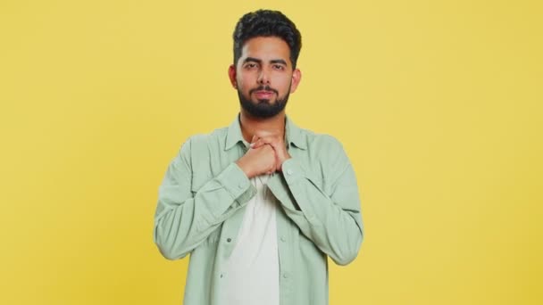 Sad young Indian man feeling hopelessness loneliness, nervous breakdown, loses becoming surprised by lottery results, bad fortune, loss unlucky news. Attractive Hindu guy isolated on yellow background - Footage, Video