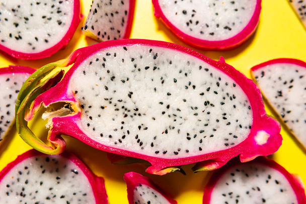 Scheiben frischer weißer Pitaya oder Drachenfrucht auf gelbem Hintergrund, flach gelegt. Konzept exotischer tropischer und veganer Kost. - Foto, Bild