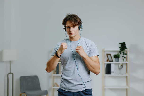 технологія чоловік онлайн підходить для м'язової діяльності в приміщенні здоров'я будинку сірий навушник спосіб життя спортзал сила чоловіче спортивне хобі здорове тренування - Фото, зображення