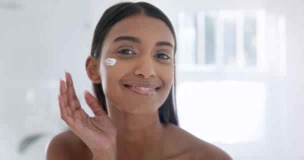 Woman, face cream and smile in bathroom with portrait, skincare or moisturizer for hydrated skin. Beauty model, indian and retinol with collagen booster, self-care and hyaluronic acid serum for pores. - Footage, Video