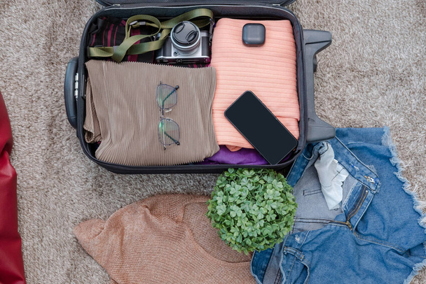 disposición de ropa y accesorios en una maleta, concepto de viaje. - Foto, imagen