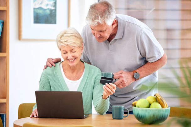 Ηλεκτρονικό εμπόριο, ώριμο ή ευτυχισμένο ζευγάρι με laptop, πιστωτική κάρτα ή κωδικό έκπτωσης για το ψηφιακό προϊόν στο σπίτι. Καφές, online ψώνια promo ή ηλικιωμένους στην ιστοσελίδα fintech για την πληρωμή ή την πώληση αναζήτησης. - Φωτογραφία, εικόνα