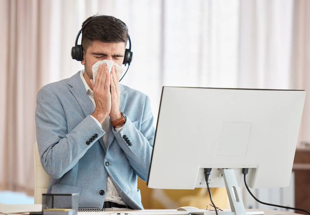 Consultant, sick or man blowing nose in call center telecom office with hay fever sneezing or illness. Cold, contact us or sales agent with toilet paper tissue, allergy virus or flu disease at work. - Photo, Image