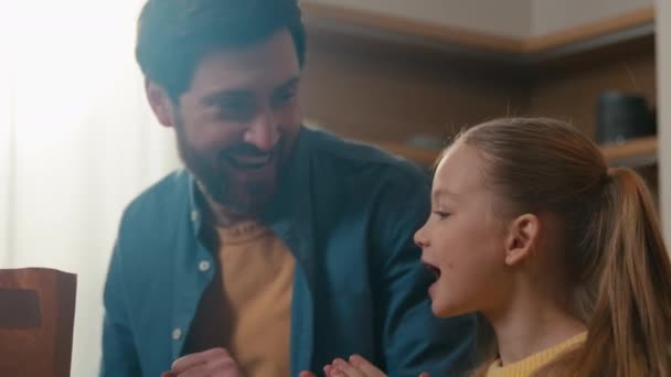 Kafkasyalı mutlu bir aile babası babası babası küçük bir kız çocuğu mutfakta alışveriş çantalarını açıyor teslimat mağazası servisinden alışveriş yapıyor dans ediyor şarkı söylüyor alkışlayarak eğleniyor - Video, Çekim