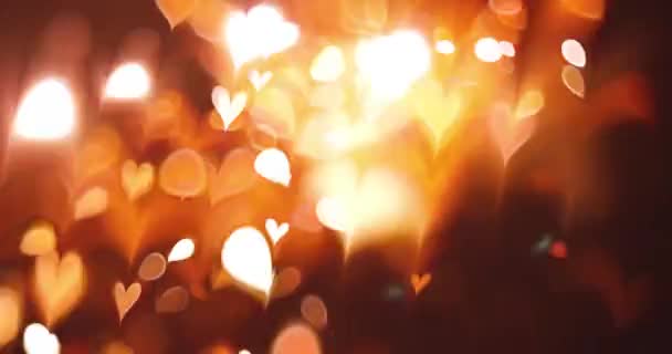 Glowing heart bokeh effect on black background. Romantic Abstract Motion Background. Valentine's Day, Festival Event, Wedding, Confetti, Christmas, Diwali, Celebration, New Year. - Footage, Video