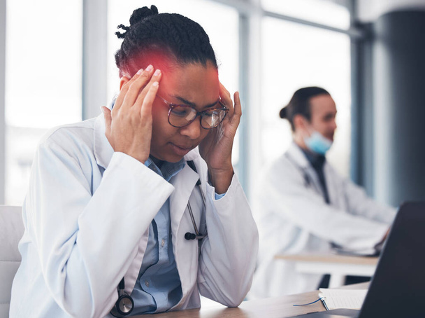 Woman, doctor and headache at desk or healthcare burnout at hospital, mental stress or tired. African female professional, fatigue and pain at laptop or working brain fog depression, vertigo or sick. - Photo, Image