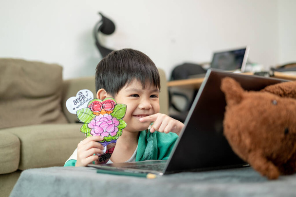 Азіатський хлопчик вивчає онлайн і займається спортом на ноутбуці - Фото, зображення