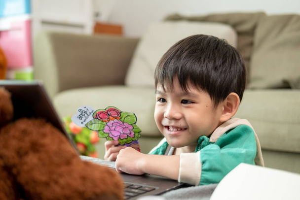 Asiatischer Junge lernt online und macht Aktivitäten am Laptop - Foto, Bild