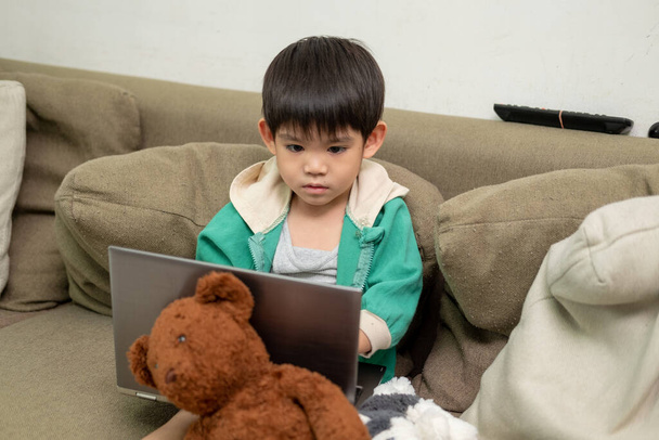 Азіатський хлопчик вивчає онлайн і займається спортом на ноутбуці - Фото, зображення