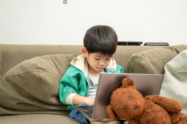 aziatische jongen studeren online en doen activiteiten op laptop - Foto, afbeelding