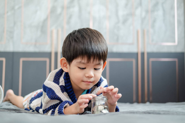Asijský chlapec šťastně počítání mincí ušetřit peníze - Fotografie, Obrázek
