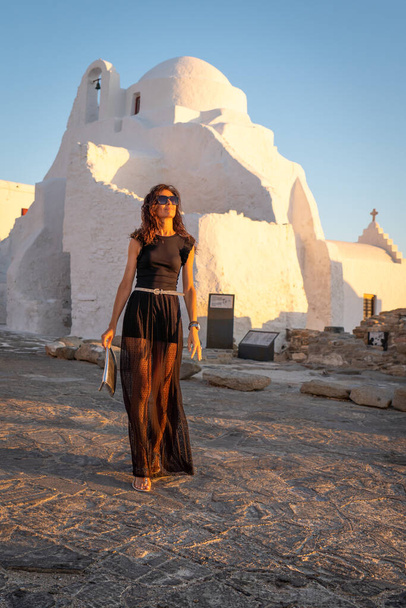 Frau in schwarzem Kleid posiert in Panagia Paraportiani, Mykonos - Foto, Bild
