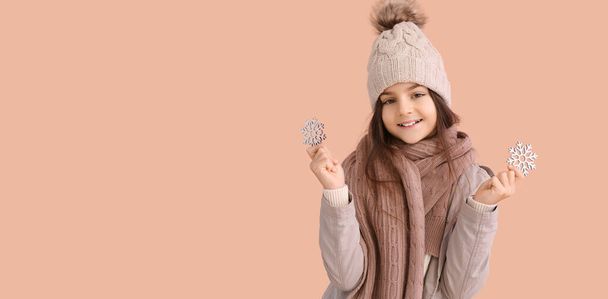 Ragazzina carina in abiti invernali e con fiocchi di neve su sfondo beige con spazio per il testo - Foto, immagini