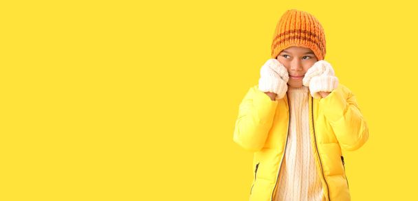 Menino afro-americano bonito em roupas quentes de inverno no fundo amarelo com espaço para texto - Foto, Imagem