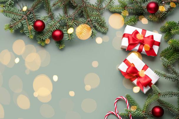 Vánoční dárky, jedle větve a dekor na zeleném pozadí s prostorem pro text - Fotografie, Obrázek