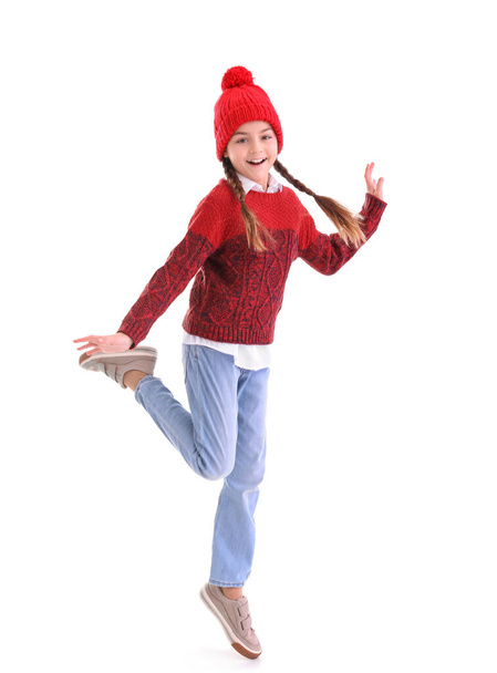 冬の服の小さな女の子は白い背景にジャンプ - 写真・画像