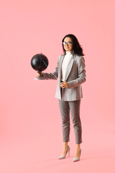 Geography teacher with globe and pointer on pink background - Photo, Image