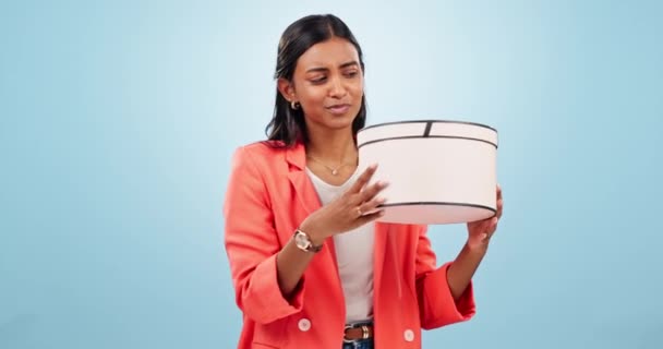 Woman, happy and shake gift box in studio of birthday present, product deal or winning prize on blue background. Curious indian model, giveaway winner or guess surprise in package, parcel or unboxing. - Footage, Video