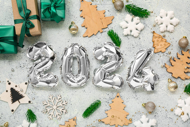 Composition avec figurine en ballons de papier d'aluminium, décorations de Noël et cadeaux sur fond clair - Photo, image