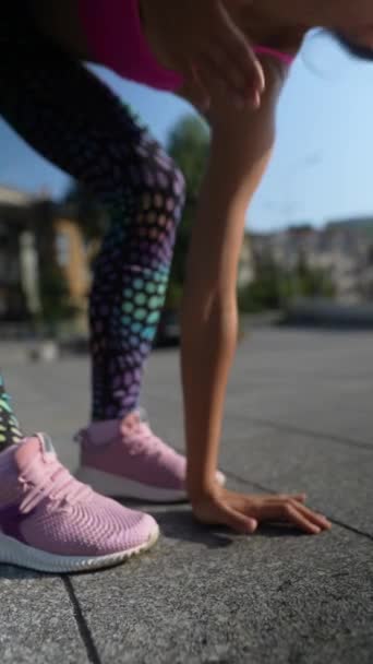 Ohromující mladá dáma v pestrobarevných sportovních šatech provádí zahřívací cvičení na ulicích města. Vysoce kvalitní 4K záběry - Záběry, video