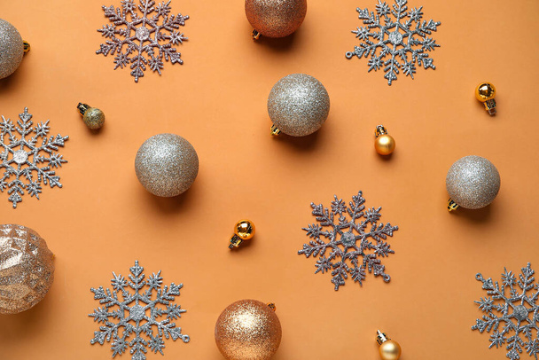 Kerstballen en sneeuwvlokken op oranje achtergrond - Foto, afbeelding