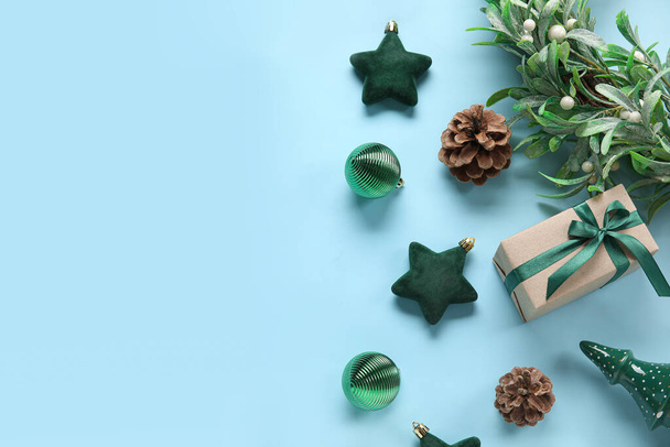 Bolas de Navidad con rama de muérdago y caja de regalo sobre fondo azul - Foto, imagen