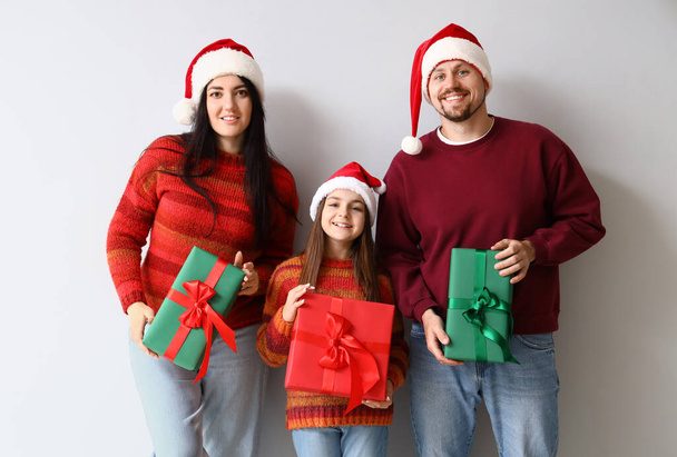 Famiglia felice con regali di Natale su sfondo chiaro - Foto, immagini